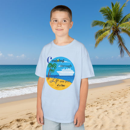 Boy wearing a blue t-shirt with a colorful ship beach and palm tree graphic design and 'Cruisin' through Life One Port at a Time' Text