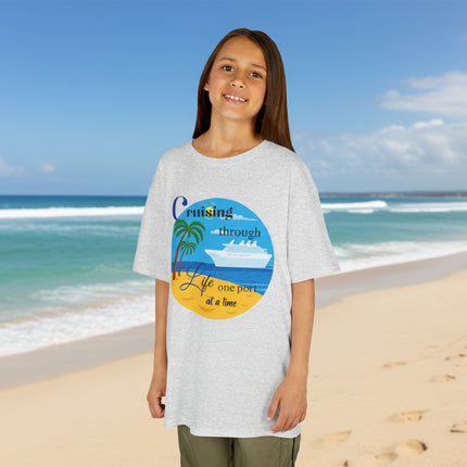 Girl wearing a gray t-shirt with a colorful ship beach and palm tree graphic design and 'Cruisin' through Life One Port at a Time' Text