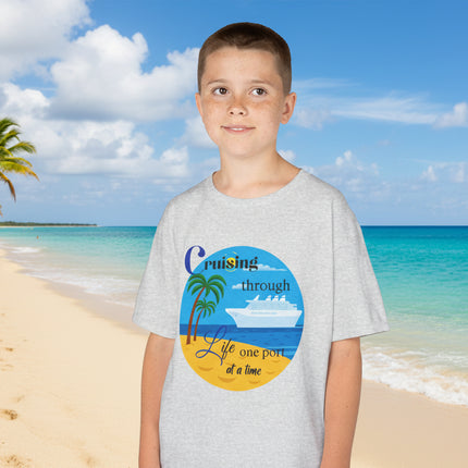 Boy wearing a gray t-shirt with a colorful ship beach and palm tree graphic design and 'Cruisin' through Life One Port at a Time' Text