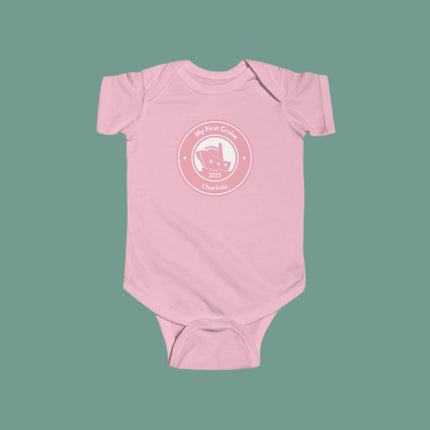 Pink baby onesie with a white graphic and text on a gray background