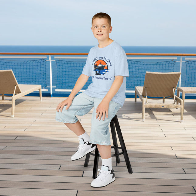 Young boy wearing a blue t-shirt with a cruise ship graphic design and text 'Countdown is Over It's Cruise Time'